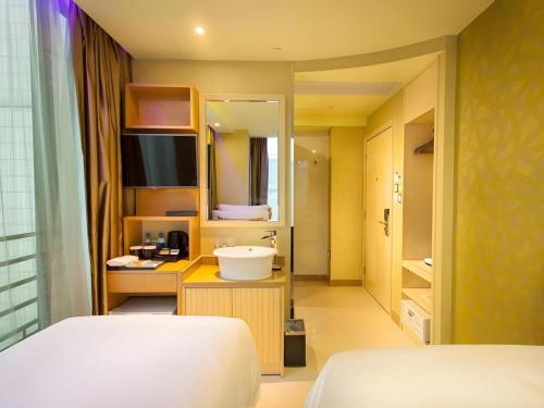 a bedroom with a bed and a sink and a mirror at Harbour Bay Hotel in Hong Kong