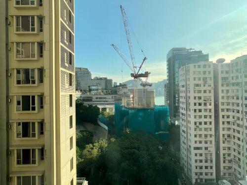 a view of a city with tall buildings and a crane at Harbour Bay Hotel in Hong Kong