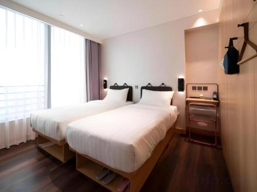 a bedroom with two beds and a window at Harbour Bay Hotel in Hong Kong