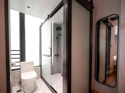 a bathroom with a toilet and a glass shower at Harbour Bay Hotel in Hong Kong