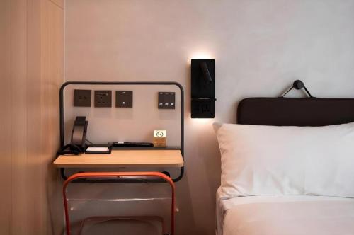 a bed room with a desk next to a bed at Harbour Bay Hotel in Hong Kong