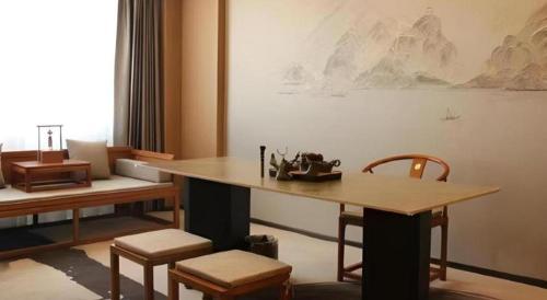 a room with a table and chairs and a painting at Yanji Yanbian International Hotel in Yanji