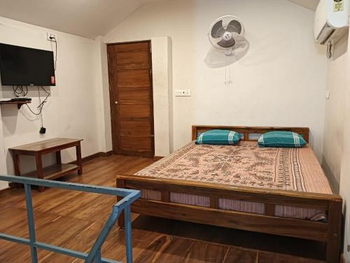 a bedroom with a large bed with a tv on the wall at SAN Brick cottages in Kuilapayam