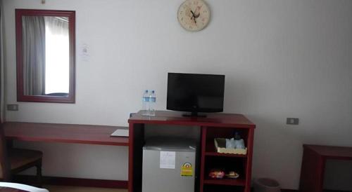 a room with a tv and a small cabinet with a small refrigerator at Hungheuang Hotel in Savannakhet