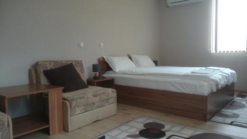 niewielka sypialnia z łóżkiem i krzesłem w obiekcie Andreevite Houses w mieście Saparewa Banja