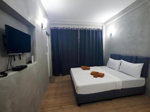a bedroom with a bed with a teddy bear on it at Ma-Kham Forest Resort in Nakhon Nayok