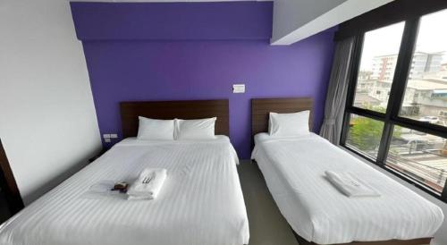 two beds sitting next to each other in a room at Wsotel Hotel in Songkhla
