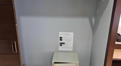 a white wall with a sign on top of a microwave at Wsotel Hotel in Songkhla