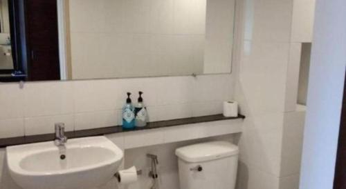 a bathroom with a sink and a toilet and a mirror at Wsotel Hotel in Songkhla