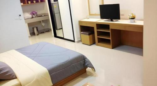 a bedroom with a bed and a desk with a television at Ipremium Sukhumvit 81 Hotel in Bangkok