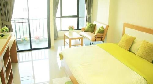 a bedroom with a bed and a couch and windows at Ipremium Sukhumvit 81 Hotel in Bangkok