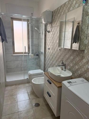 a bathroom with a toilet and a sink and a shower at O forse il mare apartamento in Marina di Strongoli