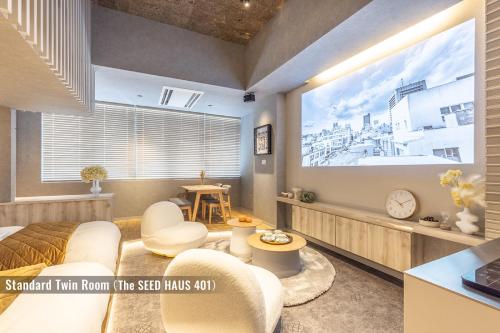 a living room with a large projection screen at ビル泊 -Birupaku Decentralized Hotel- in Shizuoka