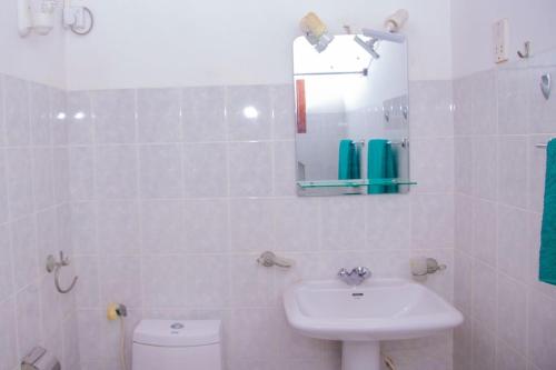 a white bathroom with a sink and a toilet at Zapo Villa in Balapitiya