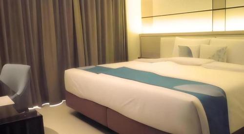 a bedroom with a large bed in a hotel room at Java Lotus Hotel Jember in Jember