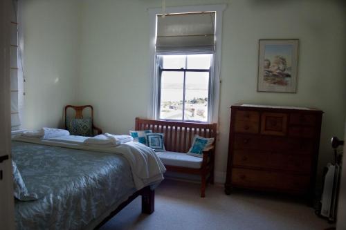 a bedroom with a bed and a chair and a window at Lotti's House in Albany