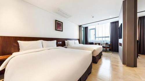a hotel room with two beds and a table at CS Premier Hotel in Seoul