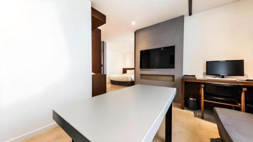 a living room with a white table and a tv at CS Premier Hotel in Seoul