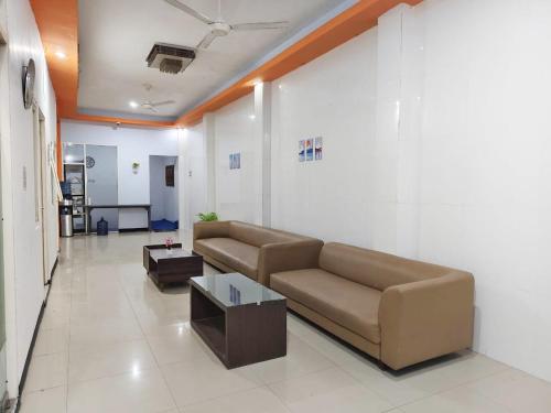 a living room with a couch and a coffee table at YUTAKA INN Nabila Juanda Airport Sidoarjo in Semampir