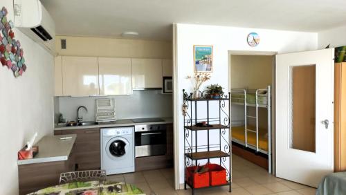 - une cuisine avec lave-linge et sèche-linge dans la chambre dans l'établissement Studio Cabine Climatisé tout près de la plage, au Grau-du-Roi