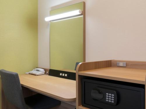 an office with a mirror and a desk with a phone at Comfort Hotel Toyohashi in Toyohashi