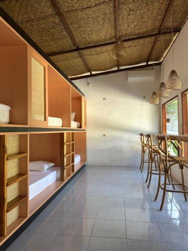 a room with a bed and a table and chairs at Kelapa Lodge - Lombok - in Senggigi 