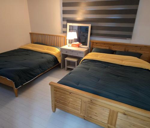 a bedroom with two beds and a vanity with a mirror at Love & Travel House in Seoul