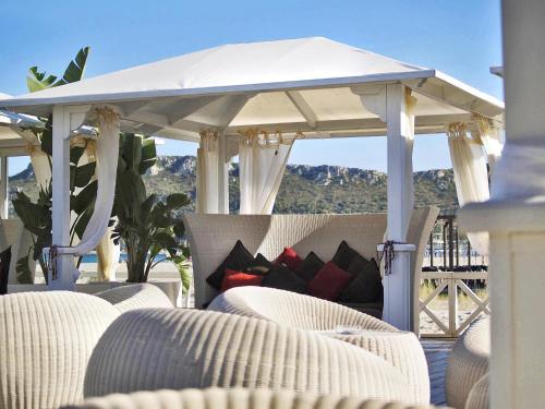 a white gazebo with chairs and a table at Hotel Villa Fanny in Cagliari