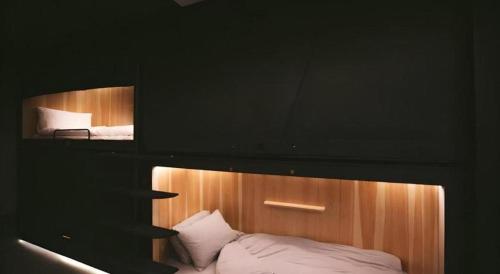 a bedroom with a bunk bed with white sheets at SLEEEP HKG Causeway Bay in Hong Kong
