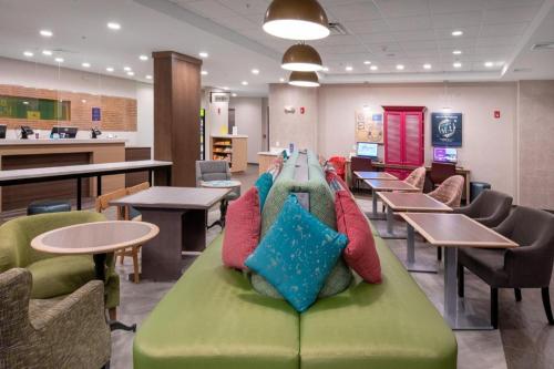 a couch with pillows on it in a cafeteria at Home2 Suites by Hilton Raynham Taunton in Raynham