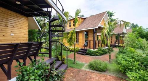 a house with a staircase in front of it at Chang Puak Resort Damnoen Saduak in Ratchaburi