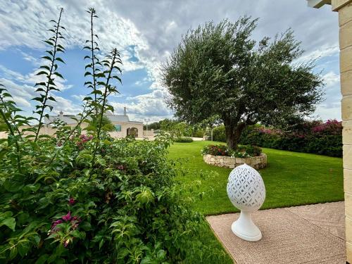 a white vase sitting in the middle of a garden at Santo Stefano in Monopoli