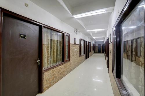 a hallway with a row of doors and paintings on the walls at Hotel O Vasant Vilas in New Delhi