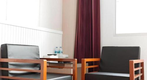 two chairs and a table in a room at Merlin Hotel in Sungai Kolok