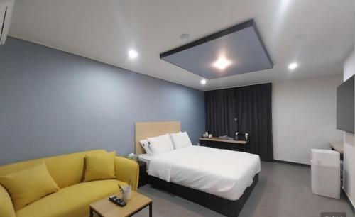 a hotel room with a bed and a couch at 숲속온천호텔 in Changwon