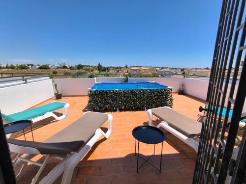 a patio with chairs and a table on a roof at Santa Rita Guest House in Olhão