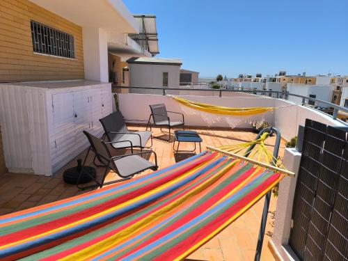 Una hamaca colorida en lo alto de un balcón. en Santa Rita Guest House, en Olhão