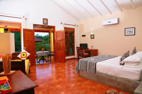 a bedroom with a bed and a living room at Shangri-Lanka Village in Tissamaharama