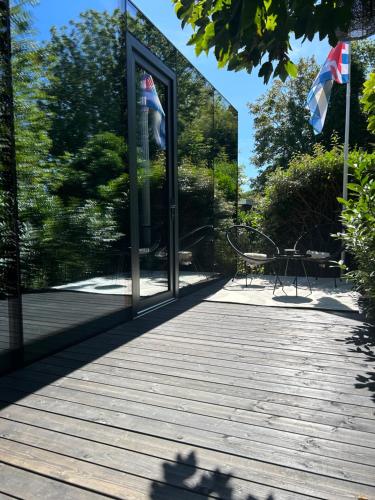 a building with glass doors and a wooden floor at Spiegelhuisje aan zee in Burgh Haamstede