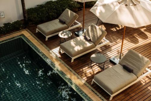 an overhead view of a pool with chairs and an umbrella at Athena Hotel in Pakse