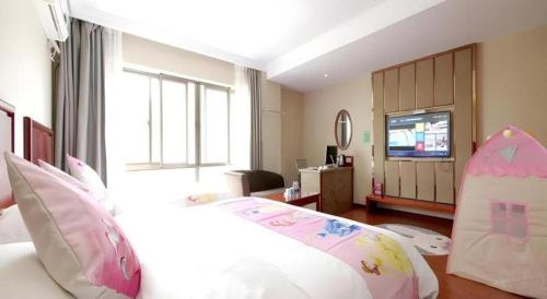 a hotel room with a bed and a television at GreenTree Inn ChiZhou QinGYAng Miaoqian Road Rongxing Building Business Hotel in Chizhou