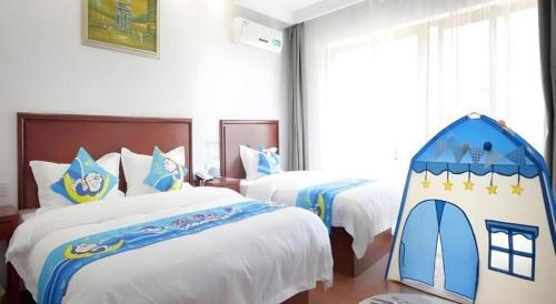 a hotel room with two beds and a tent at GreenTree Inn ChiZhou QinGYAng Miaoqian Road Rongxing Building Business Hotel in Chizhou