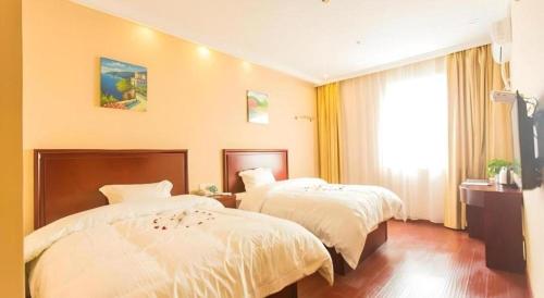 a hotel room with two beds and a window at GreenTree Inn Taizhou New District Hospital of Renmin Hospital Mingliu Express Hotel in Jiuligou