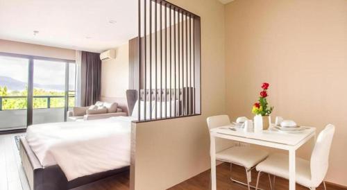 a hotel room with a bed and a table and chairs at Green Valley Executive Serviced Residence in Chiang Mai