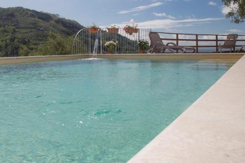 a swimming pool with a fountain in the middle at Podere Scoglio d'Oro in Pescia