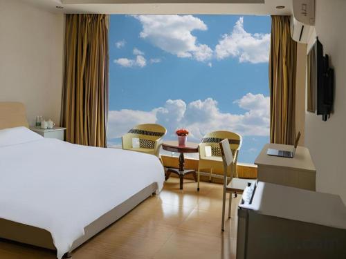 a bedroom with a bed and a table and a large window at Jian Guo Grand Hotel in Vientiane