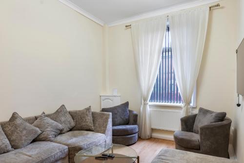 a living room with a couch and two chairs and a window at Relax in Comfort 3BR Home for 6 with Full Kitchen, Lounge, Large Bath in Bury