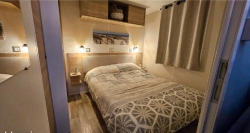 Un dormitorio pequeño con una cama y una ventana. en MOBILE-HOME Bonne Anse plage, en Les Mathes