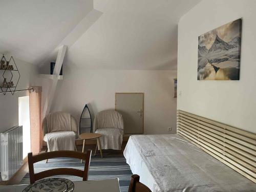 une chambre avec un lit, une table et des chaises dans l'établissement Les Chambres avec SDB,1 Studio l'intérieur complètement rénové en 2024,plage du Débarquement 5 minutes à pied, à Vierville-sur-Mer