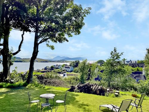 a table and chairs on a lawn next to a lake at Applecross Manse in Applecross
